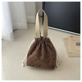Close-up of brown corduroy bucket bag with heart patterns and cotton drawstring detail - Brown