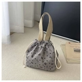 Detail of corduroy bucket bag with drawstring closure and woven handles in mauve - Gray