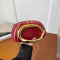 Vibrant red glossy leather handbag with a gold circular handle and metal chain strap - Red
