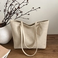Chic beige tote bag with embossed texture and double shoulder straps on wood table - Khaki