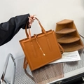 Caramel brown leather tote bag with gold metal accents and adjustable shoulder strap - Brown
