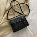 Vista dall'alto di una borsa a tracolla nera in similpelle su un maglione in maglia beige - Nero