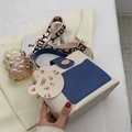 Stijlvolle crème en marineblauwe crossbody tas met brede geweven riem en schattige hanger - Blauw