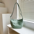 Light green minimalist canvas crossbody bag with adjustable strap and crescent shape - Green