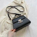 Chic black trapezoid handbag with gold T-clasp and adjustable leather shoulder strap - Black