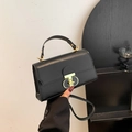 Bolso bandolera negro mate clásico con asa superior y cierre de metal en T dorado - Negro