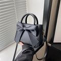 Elegante schwarze Handtasche mit großer Schleife, verstellbarem Schultergurt und rundem Griff - Schwarz