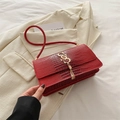 Chic red crocodile pattern shoulder bag with gold logo paired with a cream blazer - Red
