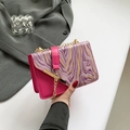 Borsa a tracolla rosa con patta marmorizzata e catena dorata tenuta in mano - Rosa Rosso