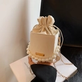 Cream bucket bag featuring a large pearl handle and a slim gold chain shoulder strap - White