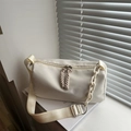 Minimale crème cilindervormige crossbodytas met brede riem en ketting op boeken - Wit