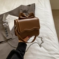 Brown faux leather crossbody bag featuring 3D bow design and wavy flap detail - Coffee