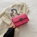 Sac carré rose effet crocodile avec bandoulière chaîne sur un blazer beige chic - rose vif