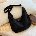 Minimalist black nylon hobo crossbody bag with wide shoulder strap and woven zipper detail - Black