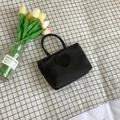 Minimalist black bucket tote bag with heart smiley patch on a checkered background - Black