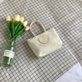 Creamy white nylon bucket handbag with a heart-shaped smiley patch on a checkered mat - White