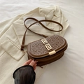 Bruine halfronde baguette tas met geometrische textuur en gouden gesp op een blazer - Bruin