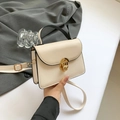 Chic cream crossbody bag with black handle and gold twist lock in hand - Khaki