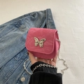 Rosafarbene Metallic-Umhängetasche mit silbernem Schmetterling und feiner Kette in der Hand - Rosa