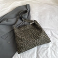 Schicke Canvas-Einkaufstasche mit Leopardenmuster auf weißem Bettlaken mit Blazer - Grau