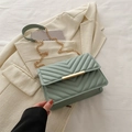 Piccola borsa a tracolla trapuntata verde chiaro con chiusura dorata e catena su blazer - verde chiaro