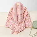 Detail of pink knitted shawl with plush faux fur collar and fringe hem on wooden hanger - Letter F / Pink