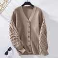 Detail der khakifarbenen Strickjacke mit Wabenärmeln und braunen Holzknöpfen - Khaki