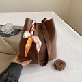 Donkerbruine bucket bag van generfd leer met decoratieve sjaal en lange schouderband - koffiekleur