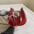 Dark red crescent shoulder bag in glossy leather with silver beaded bow detail - Red