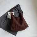 Bolso tote de ante marrón oscuro con correa de hombro minimalista sobre blazer gris - café