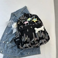 Schwarzer gesteppter Rucksack mit Stickereien und Plüschsternen auf Denimjacke - Schwarz