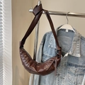 Bolso croissant marrón oscuro minimalista con costuras acolchadas y detalle de nudo - café