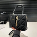 Black quilted crossbody bag with large triangular stitching and gold tassel charm - Black