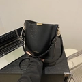 Minimalist black bucket bag with a stylish woven handle and golden metallic buckle - Black