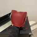 Minimalist burgundy bucket bag with woven handle and sleek leather shoulder strap - Red
