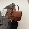 Brown patchwork contrast shoulder bag with top handle and fashion tag in urban setting - Brown