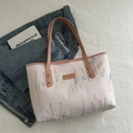 Borsa tote rosa trapuntata con ricami colorati e manici in pelle su sfondo bianco - Rosa