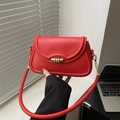 Elegante bolso de hombro rojo con hebilla dorada en un entorno de oficina moderno - Rojo