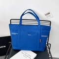 Large royal blue canvas tote bag on a modern mesh chair for daily fashion commute - Blue