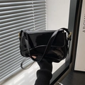 Schwarze Lackleder-Schultertasche mit goldenen Beschlägen und geschwungener Klappe - Schwarz