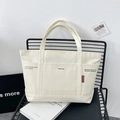 Large white canvas tote bag with multi-pocket design and front text print for women - Off White