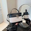 Retro canvas and black leather box handbag with adjustable strap shown in front of mirror - Black