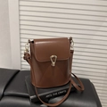 Sac seau en cuir marron minimaliste avec boucle dorée sur décor de livres d'art - Marron
