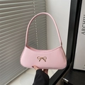 Pink baguette shoulder bag featuring a gold bow accent and sleek leather finish - Pink