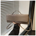 Détail d'un sac à main taupe texture crocodile avec ferrures dorées et bandoulière - Kaki