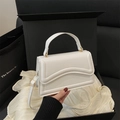 Elegant white square handbag with wavy texture and gold buckle in a minimalist gift setting - White