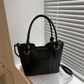 Borsa tote nera minimalista con finitura opaca e anelli in metallo dorato su rivista - Nero