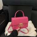 Elegante bolso rosa fucsia con relieve geométrico y cierre dorado en una caja de regalo - rosa intenso