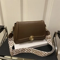 Brown lychee leather crossbody bag with golden spiral lock and geometric woven strap - Brown
