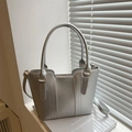 Chic silver tote bag with gold hardware and shoulder strap in minimalist design - Silver